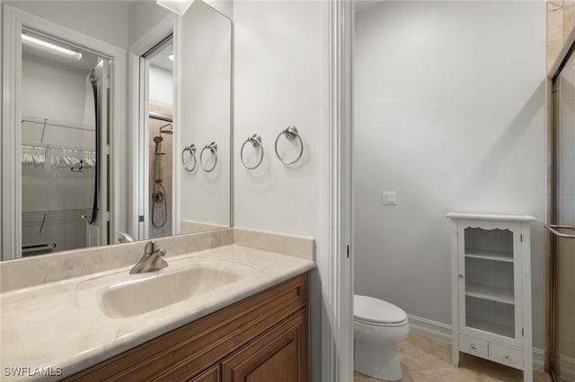 bathroom with vanity, toilet, a shower with door, and tile patterned flooring