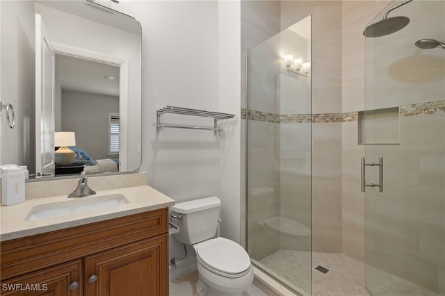 bathroom with a shower with door, vanity, and toilet