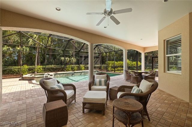 view of patio featuring ceiling fan, a swimming pool with hot tub, and a lanai