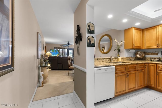 kitchen featuring light stone countertops, dishwasher, sink, ceiling fan, and light colored carpet