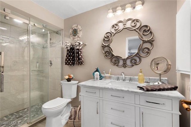 bathroom featuring toilet, walk in shower, and vanity