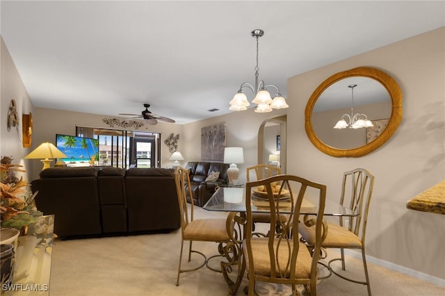 dining space featuring ceiling fan with notable chandelier and light colored carpet