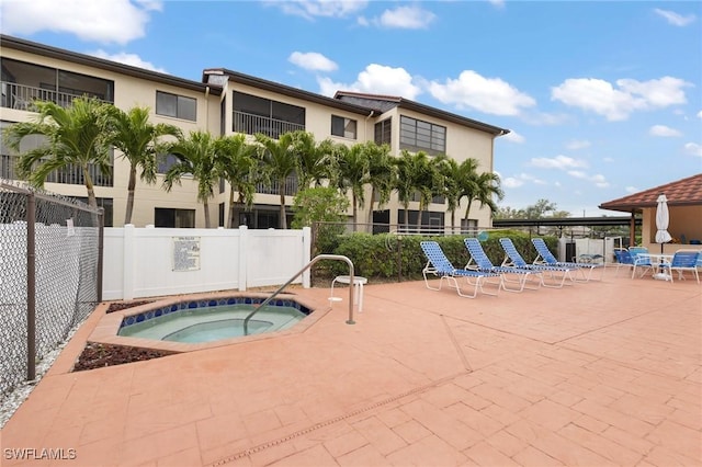 view of swimming pool featuring a patio and a hot tub