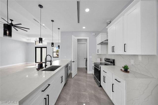 kitchen featuring white cabinetry, appliances with stainless steel finishes, hanging light fixtures, light stone countertops, and sink