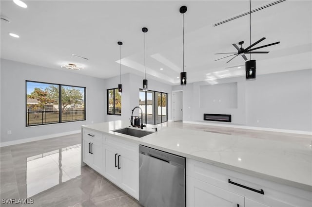 kitchen with decorative light fixtures, dishwasher, sink, white cabinetry, and light stone counters