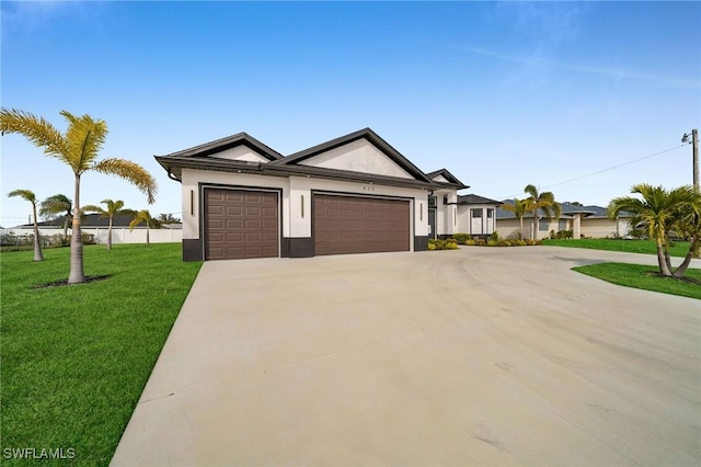 ranch-style home featuring a garage and a front lawn