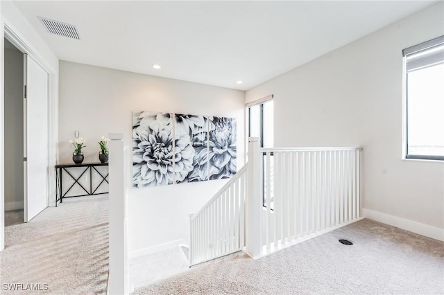 corridor featuring light colored carpet