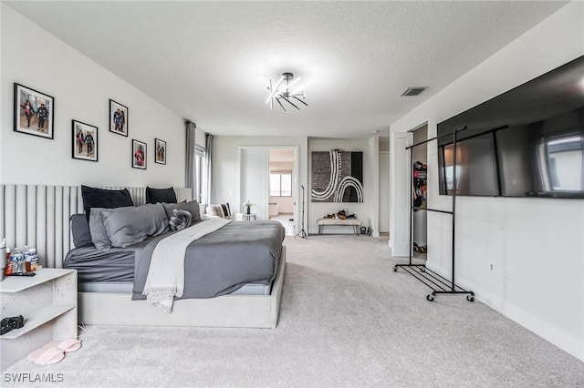 carpeted bedroom with a chandelier and a textured ceiling