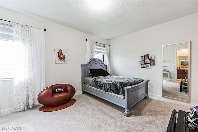 bedroom with light colored carpet and a textured ceiling