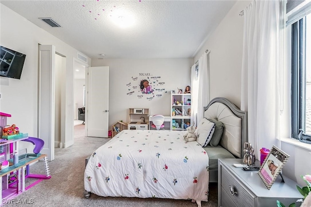 bedroom with light carpet and a textured ceiling