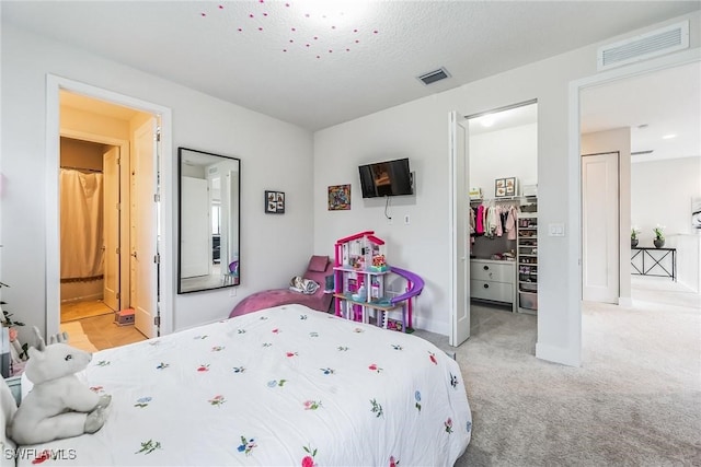 carpeted bedroom featuring ensuite bath and a closet