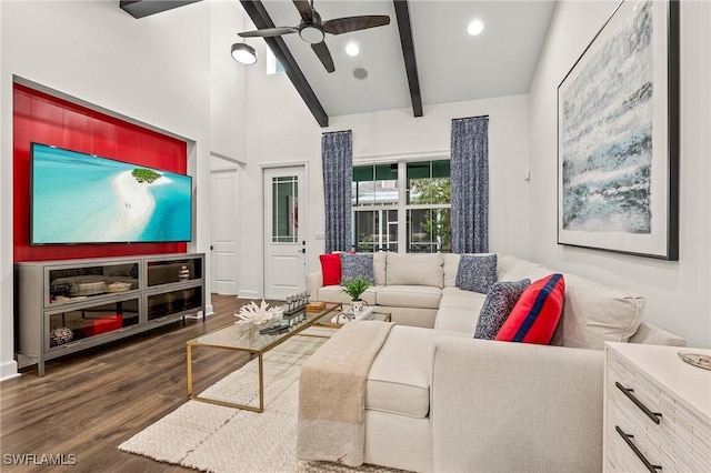 living room with ceiling fan, dark wood-type flooring, high vaulted ceiling, and beamed ceiling