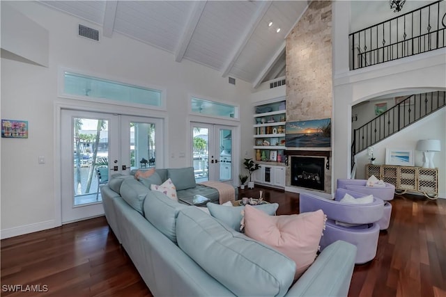 living room with hardwood / wood-style floors, built in features, a fireplace, and french doors