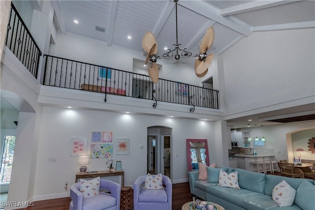 living room featuring sink, beam ceiling, high vaulted ceiling, and dark hardwood / wood-style floors