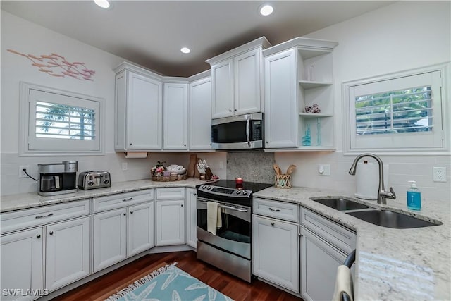 kitchen featuring dark hardwood / wood-style floors, white cabinetry, sink, light stone counters, and stainless steel appliances