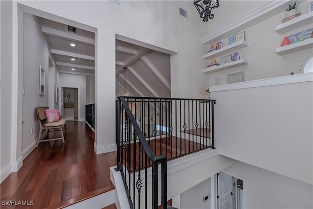 stairway with beam ceiling and wood-type flooring