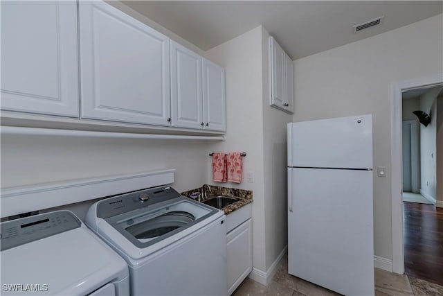 washroom featuring cabinets, sink, and washing machine and clothes dryer