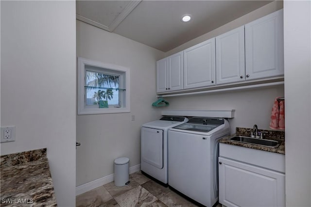 clothes washing area featuring cabinets, sink, and washing machine and clothes dryer