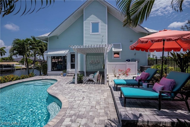 rear view of house featuring a fenced in pool, a pergola, and a patio area