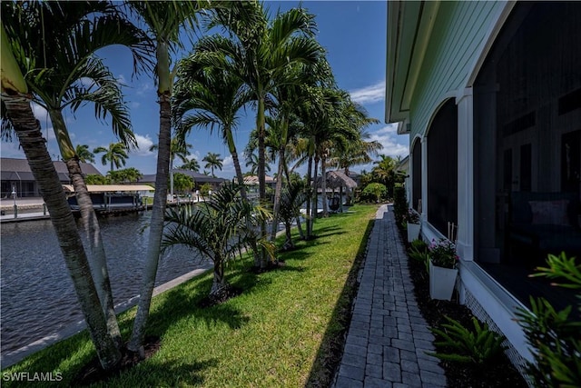 view of yard with a water view and a boat dock