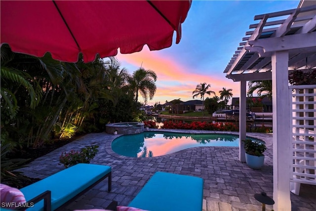 pool at dusk with an in ground hot tub, a patio, and a pergola