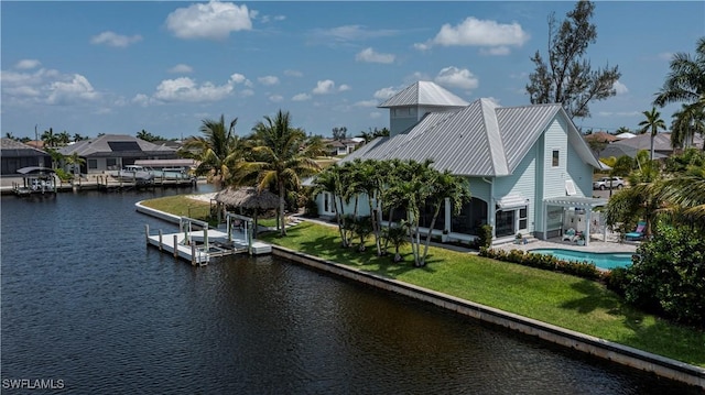 dock area with a lawn, a water view, a residential view, and an outdoor pool