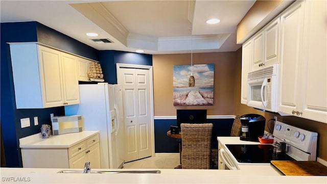 kitchen featuring light tile patterned floors, white cabinetry, a raised ceiling, white appliances, and crown molding