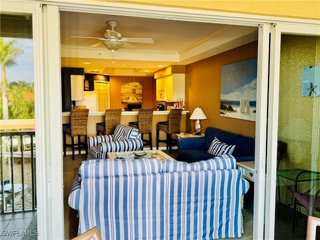 interior space featuring ceiling fan, a tray ceiling, and ornamental molding