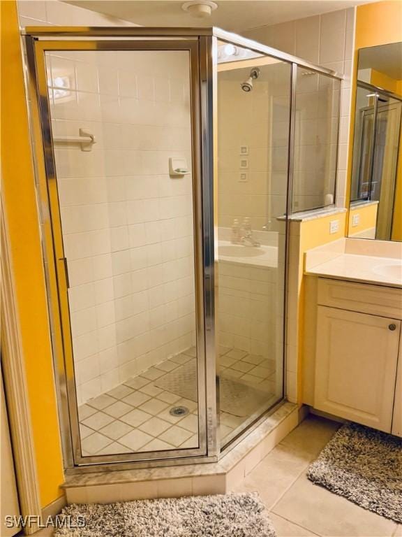 bathroom featuring vanity, a shower with door, and tile patterned floors