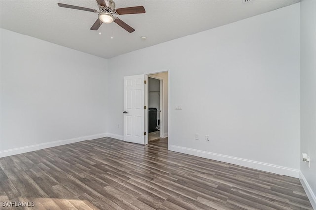 empty room featuring ceiling fan and dark hardwood / wood-style flooring