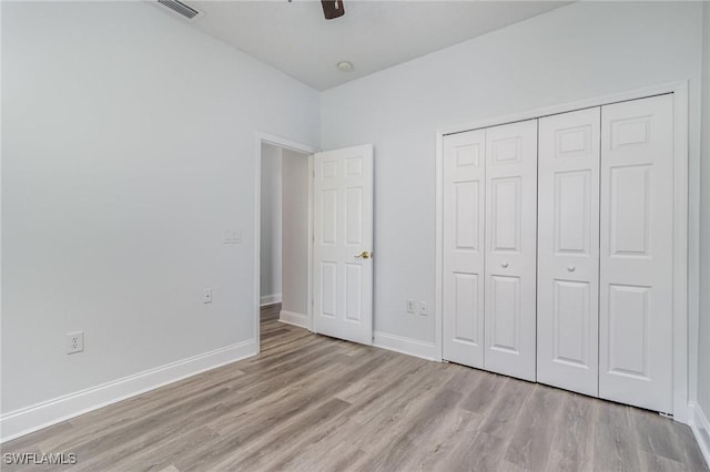 unfurnished bedroom featuring ceiling fan, a closet, and light wood-type flooring