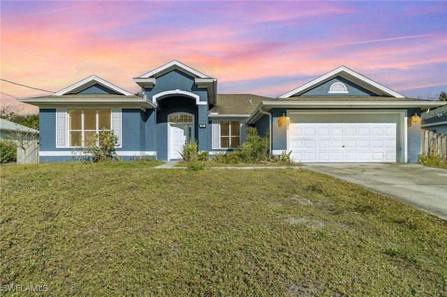 ranch-style house with a garage and a yard