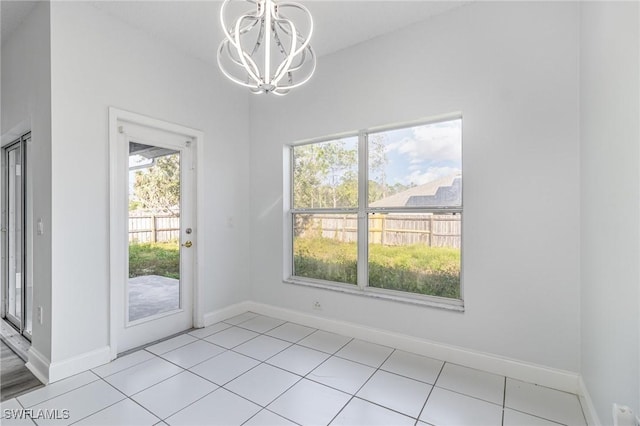 unfurnished dining area with an inviting chandelier and light tile patterned floors