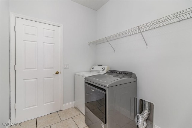 laundry area featuring light tile patterned floors and washing machine and dryer