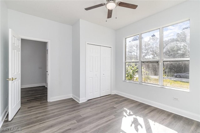 unfurnished bedroom featuring ceiling fan, hardwood / wood-style flooring, and a closet