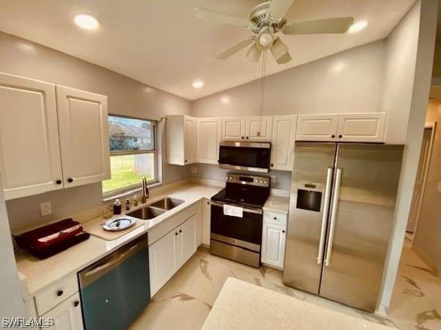 kitchen with sink, white cabinetry, stainless steel appliances, and vaulted ceiling