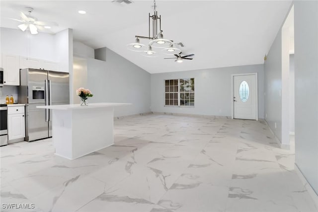 kitchen featuring hanging light fixtures, stainless steel fridge, a kitchen island, ceiling fan, and white cabinets