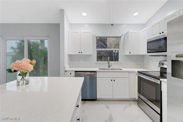 kitchen with sink, stainless steel appliances, and white cabinets