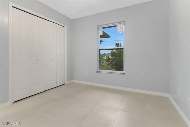 unfurnished bedroom featuring light tile patterned floors and a closet