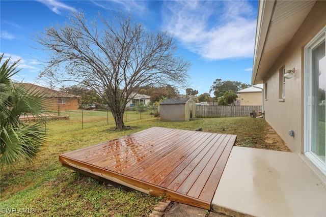 deck with a shed and a lawn