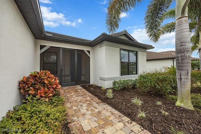 doorway to property featuring stucco siding