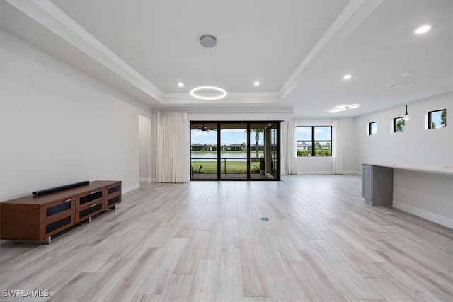 unfurnished living room featuring baseboards, a raised ceiling, ornamental molding, light wood-type flooring, and recessed lighting