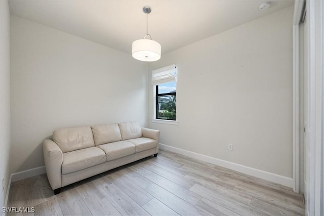 living area with light wood-style flooring and baseboards