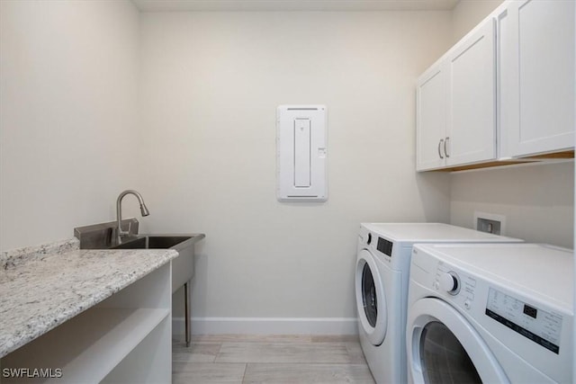 clothes washing area featuring cabinet space, baseboards, and separate washer and dryer