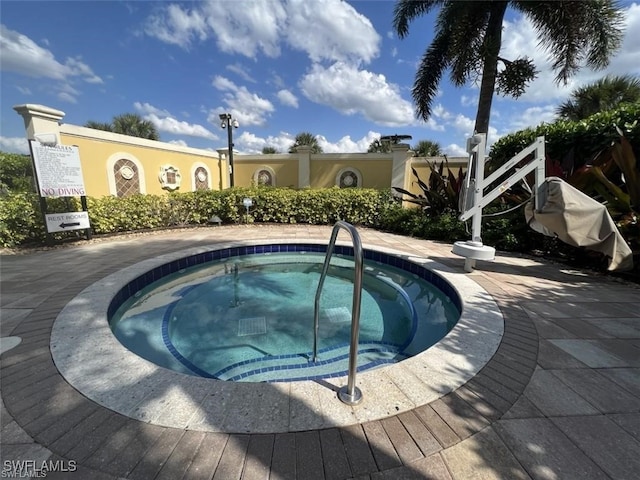 view of swimming pool featuring a hot tub