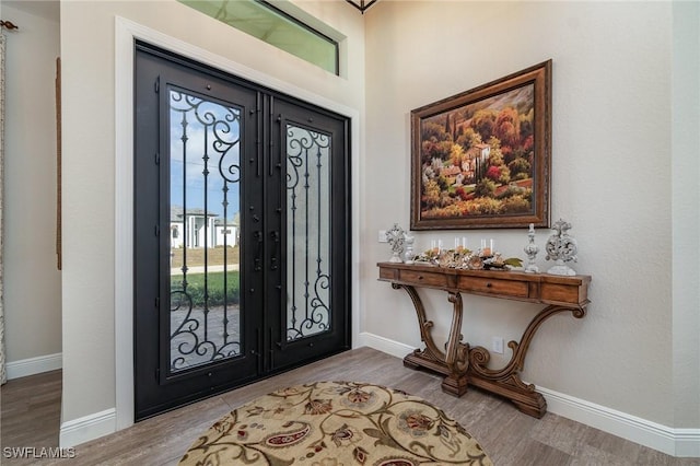 entryway with wood-type flooring and french doors