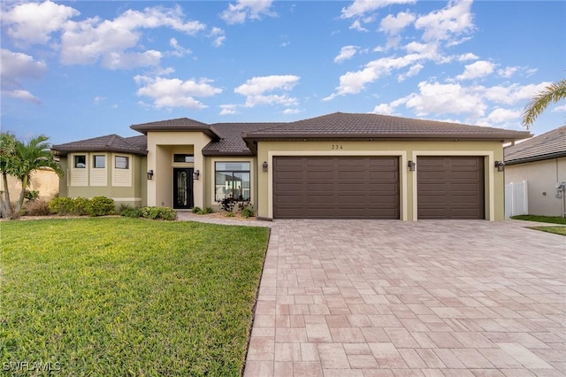 prairie-style house featuring a garage and a front yard