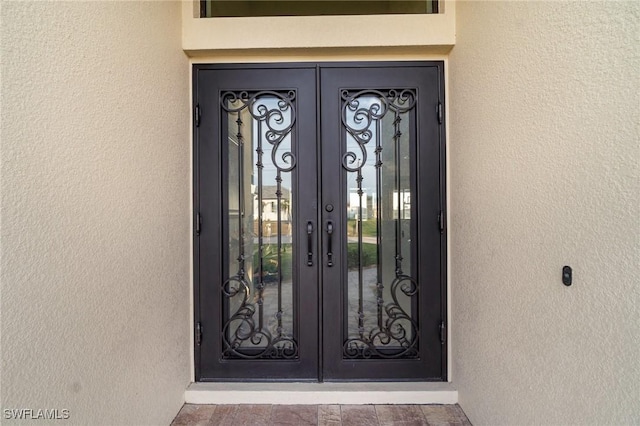 property entrance featuring french doors and stucco siding