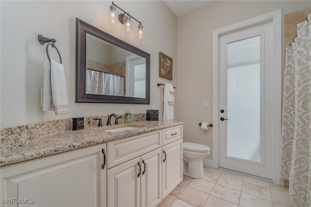 bathroom featuring vanity, tile patterned flooring, and toilet