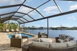 view of pool featuring an outdoor living space, a lanai, a patio area, and a water view